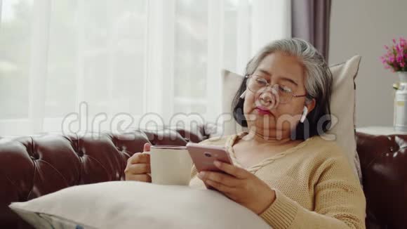 老妇人在家里快乐地听音乐视频的预览图