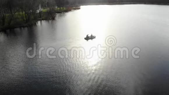 日落时两个人的橡皮船漂浮在河上视频的预览图