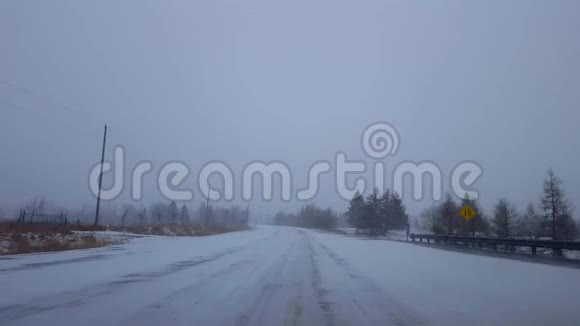 白天在农村公路上驾驶冬季暴风雪司机视角POV雪化暴雪乡村视频的预览图