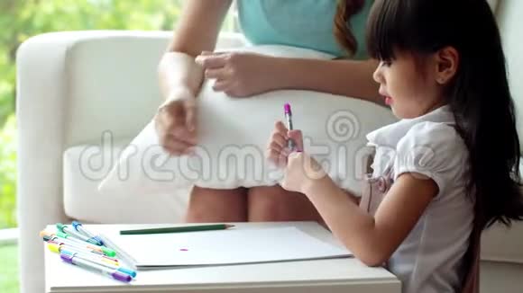 可爱的女孩选彩色铅笔和妈妈画画视频的预览图
