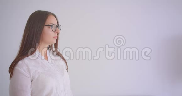 年轻漂亮的白种人女性戴着眼镜看着镜头手臂交叉在胸部视频的预览图