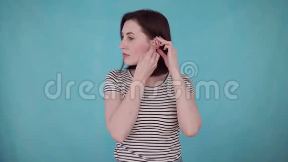 蓝底带助听器听力障碍的微笑年轻女子肖像视频的预览图