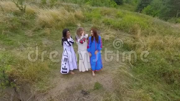 鸟瞰三个女朋友在河边的一座高山上玩得开心和大笑与自然的联系视频的预览图