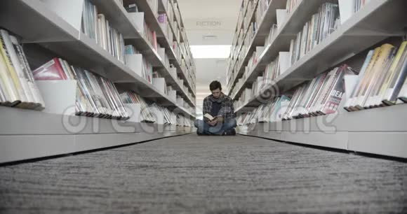 大学生坐在图书馆的地板上看书垂直形状中间视图视频的预览图