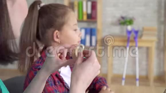 耳鼻喉科医生帮助一位听力受损的少女近距离使用助听器视频的预览图
