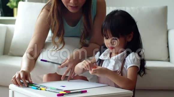 年轻的母亲帮女儿打开彩色铅笔视频的预览图