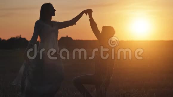 一对在日落时分相爱的舞蹈夫妇的剪影视频的预览图