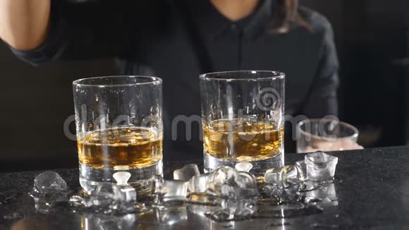 冰块掉进威士忌的玻璃杯里酒保的概念慢动作冰掉了高清高清视频的预览图