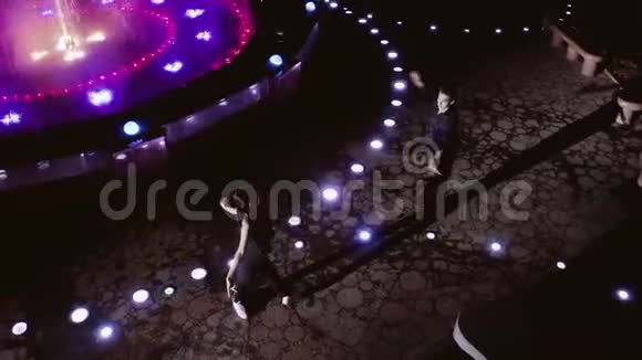 职业舞者晚上在美丽的喷泉跳舞从四翼飞机上看视频的预览图
