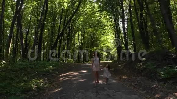 优雅的女孩和她的小女儿在树林间散步和玩耍视频的预览图