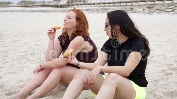 年轻女性在海滩上吃甜甜圈视频的预览图