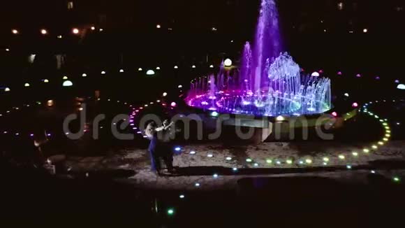 美丽的喷泉在晚上和跳舞的夫妇附近视频的预览图