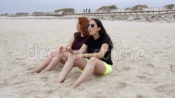 年轻女性在海滩上吃甜甜圈视频的预览图