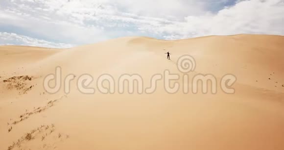 女孩在沙丘上奔跑鸟瞰蒙古戈壁沙漠的Khongor沙丘视频的预览图