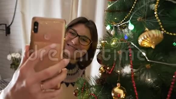 快乐的年轻女人用智能手机拍圣诞自拍节日新年幸福的概念视频的预览图