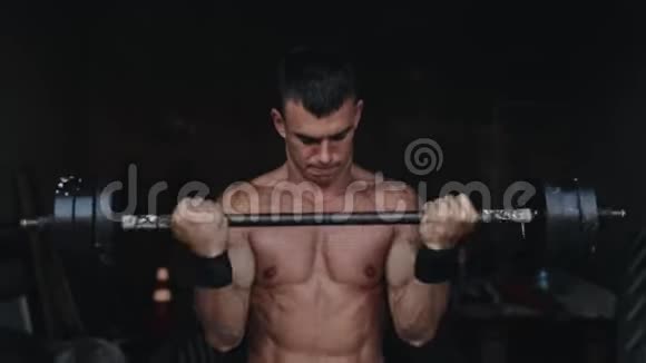 一位强壮的运动员在健身房举起杠铃的近景视频的预览图