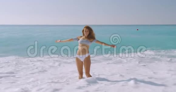 那个女人在美丽的海滩上无忧无虑女孩放松在苗条的身体里表现出快乐和快乐以减肥饮食视频的预览图