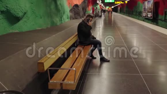 坐在长凳上五颜六色的通道里的人视频的预览图