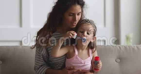 开心的妈妈在家玩女儿吹肥皂泡视频的预览图