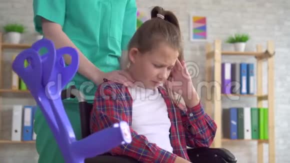 按摩师医生给坐轮椅的十几岁女孩做颈部按摩视频的预览图