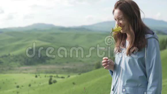 一位手里拿着一朵黄花的美女站在旁边视频的预览图