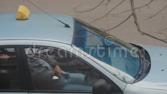 疲惫的出租车司机在停着的车里休息或睡觉手里拿着手机视频的预览图