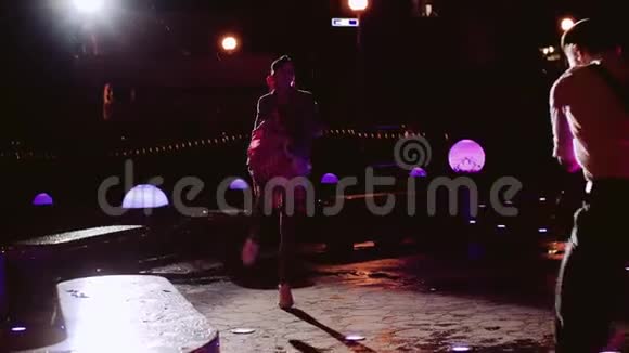 一个穿着圆点花裙的男人和一个女孩在晚上跳舞视频的预览图