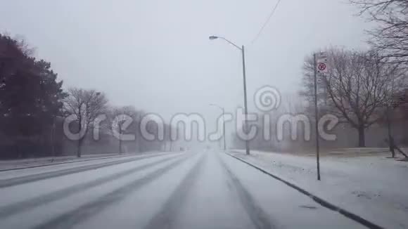 驾驶冬季暴风雪与车辆交通在白天司机视角POV雪雪暴雪天气状况视频的预览图