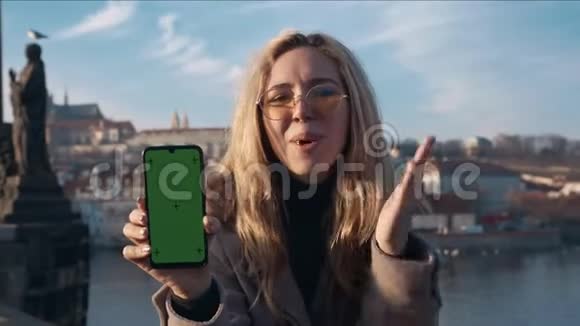 女人拿着一个带绿色屏幕的手机推广广告商业理念拍摄于雷德4k10位视频的预览图