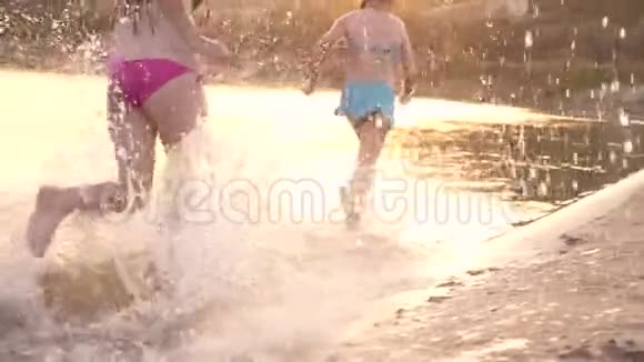 女孩们在沙滩上奔跑沙滩上溅起水滴免费青少年暑假放松视频的预览图