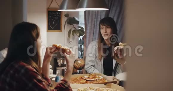 美丽的年轻白种人女人吃比萨饼与多民族的朋友在家庭聚会慢动作视频的预览图