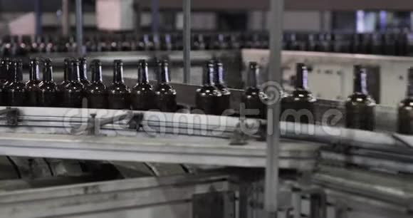 许多干净的玻璃啤酒棕色瓶子在工厂沿着输送线移动视频的预览图