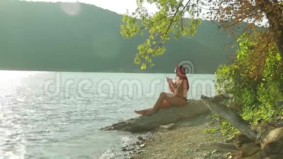 一个红头发的女人在湖边工作视频的预览图