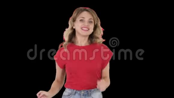 穿红色T恤和牛仔裤的跑步女孩微笑阿尔法频道视频的预览图