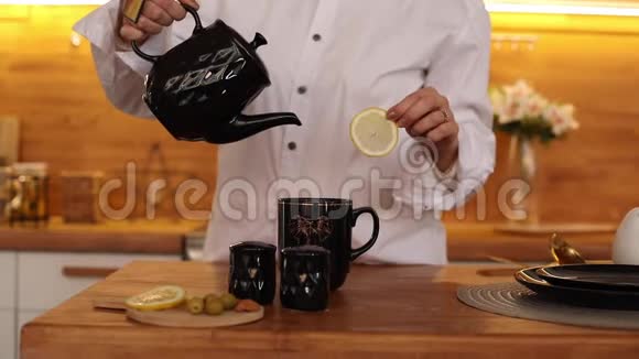 无法辨认的女人把茶倒进杯子里视频的预览图