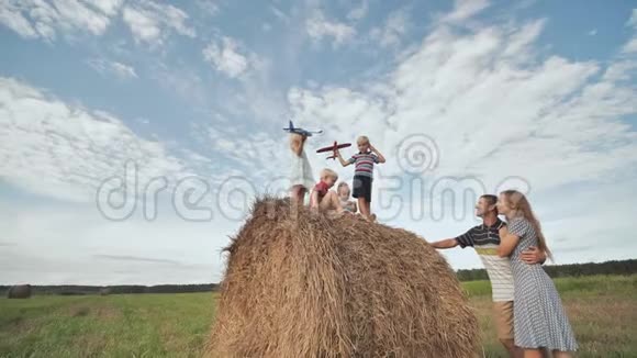 孩子们在父母面前站在一堆稻草上发射飞机视频的预览图