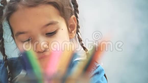 可爱的创意女孩扎着辫子从篮子里伸出一支铅笔画画模糊的铅笔放在最前面视频的预览图