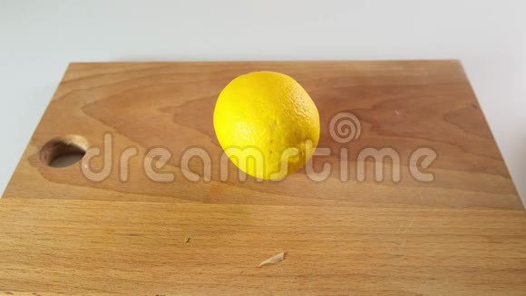 顶部的景色接近男子切割柠檬与刀在木制砧板上快关门视频的预览图