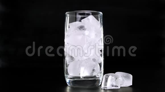在黑色背景下用玻璃倒入冰块的可乐快关门视频的预览图