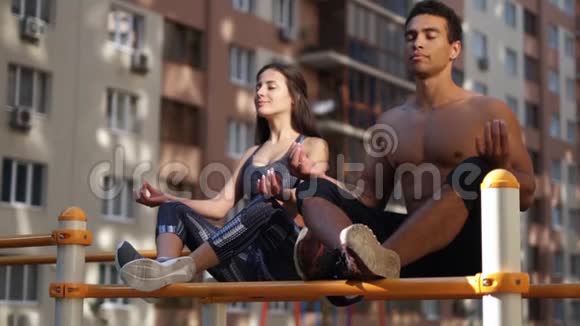 年轻的积极健身夫妇锻炼瑜伽姿势锻炼冥想长寿和健康的生活视频的预览图