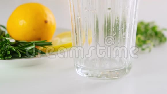 在玻璃杯中加入柠檬片的苏打水倒矿泉水快关门视频的预览图