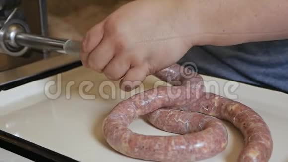 一个男人用传统的方式用香肠填料煮香肠生牛肉香肠特写肉类生产视频的预览图