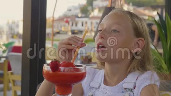 肖像少女在户外夏日咖啡馆用稻草喝草莓鸡尾酒亲密的快乐女孩享受视频的预览图