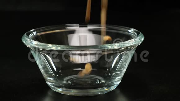 干豆倒在黑色背景的玻璃碗上快关门视频的预览图
