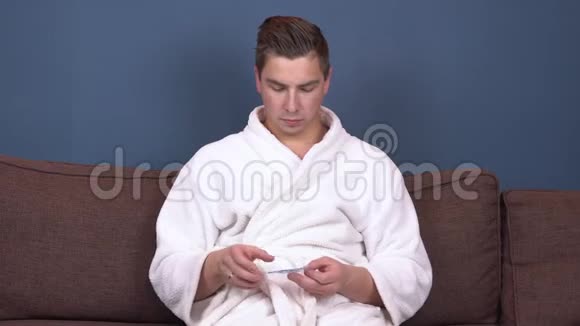 一个年轻人把补丁贴在脸上蓝色水凝胶贴片以恢复面部皮肤的活力坐在里面的人视频的预览图