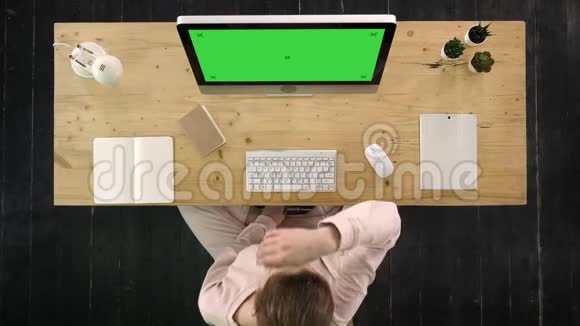 女人在电脑显示器前的办公室里伸展着紧张的脖子绿色屏幕模拟显示视频的预览图
