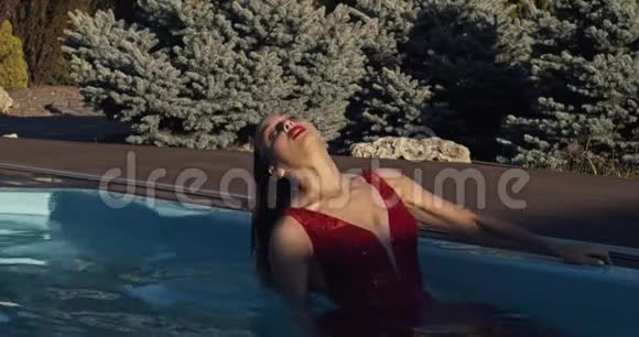 性感的年轻女子从水下出来穿着红色的衣服和化妆4K视频的预览图