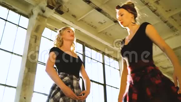 两名女舞者在阁楼工作室用镜头照明弹排练的低角度镜头视频的预览图