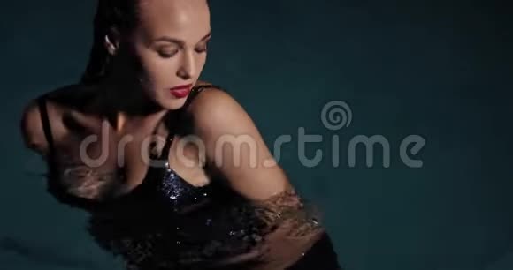 一个穿着黑色衣服的年轻女子站在游泳池里湿漉漉的头发4K视频的预览图