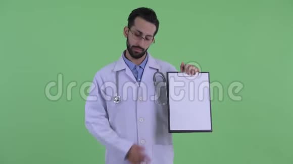 穿着有胡子的年轻波斯人医生展示剪贴板竖起大拇指视频的预览图